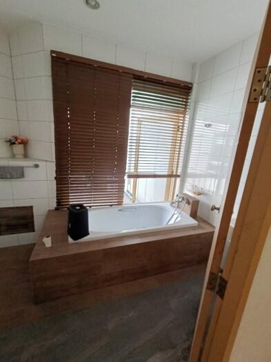 Modern bathroom with bathtub and window blinds