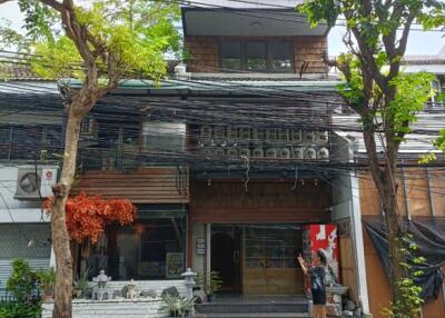 Front view of a three-story building with trees and greenery