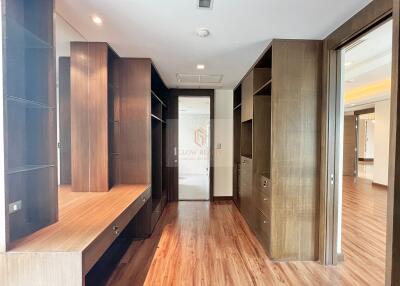 Spacious modern walk-in closet with wooden shelves and drawers