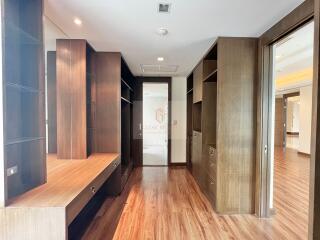 Spacious modern walk-in closet with wooden shelves and drawers