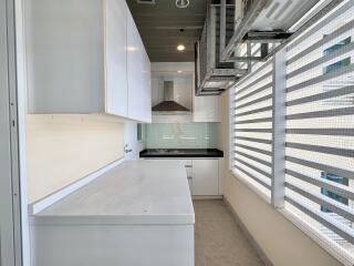 Modern kitchen with white cabinets, electric stove, and ample natural light