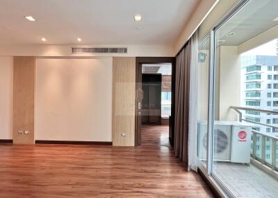 Spacious living room with wooden flooring and large windows