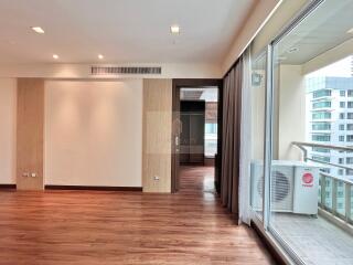 Spacious living room with wooden flooring and large windows