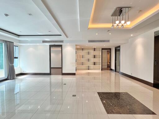 Spacious modern living room with tiled floor, large windows, and ceiling lights