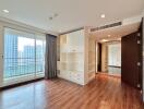 Modern living space with hardwood floors, built-in shelves, and large windows.