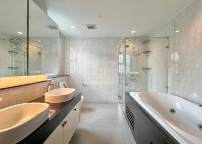 Modern bathroom with double sinks and a large bathtub