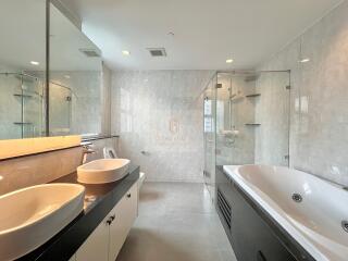 Modern bathroom with double sinks and a large bathtub