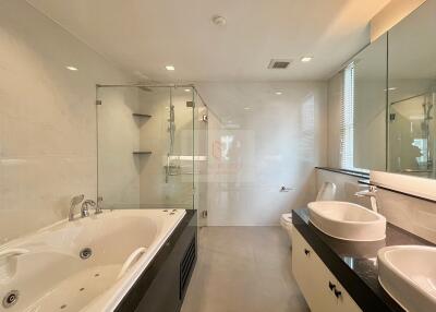 Modern bathroom with jacuzzi, glass shower, double sinks, and large mirror