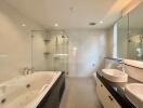 Modern bathroom with jacuzzi, glass shower, double sinks, and large mirror