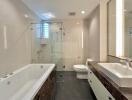 Modern bathroom with glass-enclosed shower, bathtub, and dual sinks