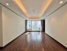 Spacious living room with large window and wooden floor