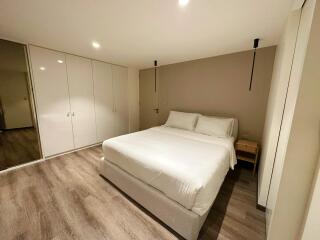 Modern bedroom with white bedding and wardrobes