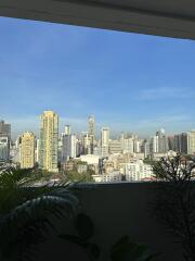 View of a city skyline from a balcony with plants