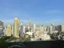 View of a city skyline from a balcony with plants