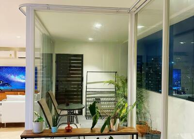 Modern enclosed balcony with plants and seating area