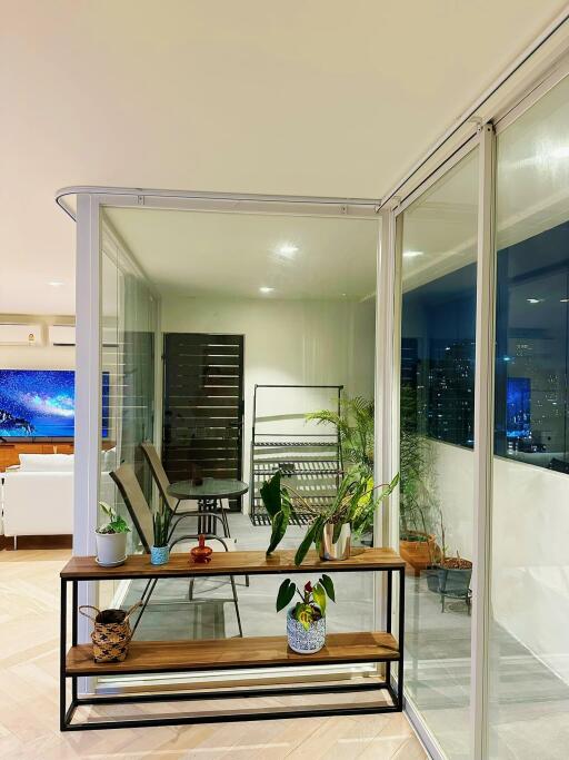 Modern enclosed balcony with plants and seating area