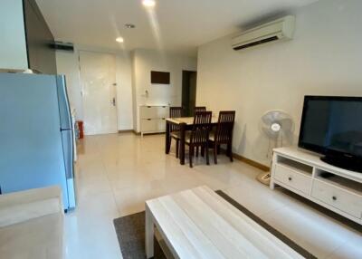 Living area with dining table, TV, and air conditioning