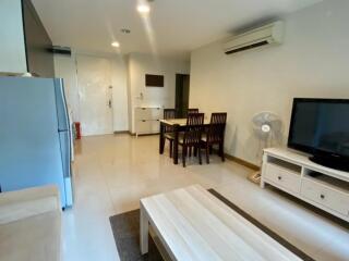 Living area with dining table, TV, and air conditioning