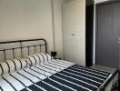 Modern bedroom with striped bedding and a metal bed frame