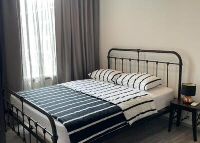 Modern bedroom with metal bedframe and striped bedding