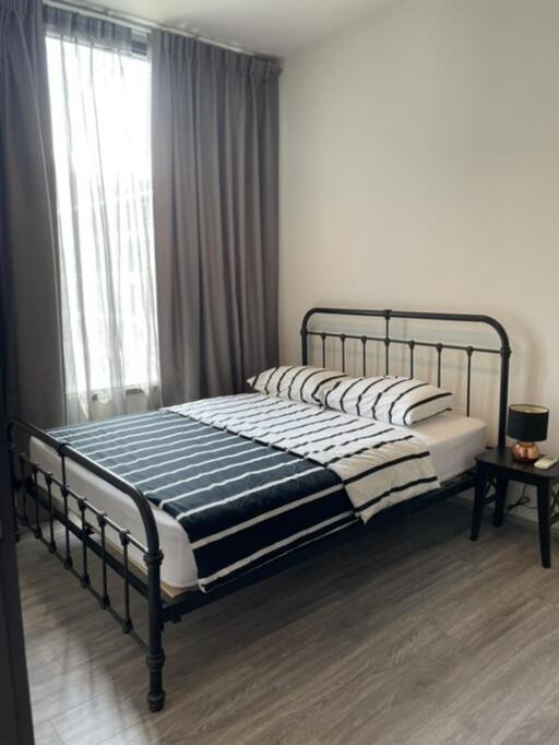 Modern bedroom with metal bedframe and striped bedding