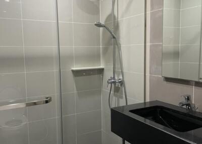 Modern bathroom with glass shower enclosure and black sink