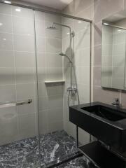 Modern bathroom with glass shower enclosure and black sink