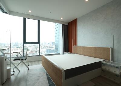 Modern bedroom with large window overlooking cityscape