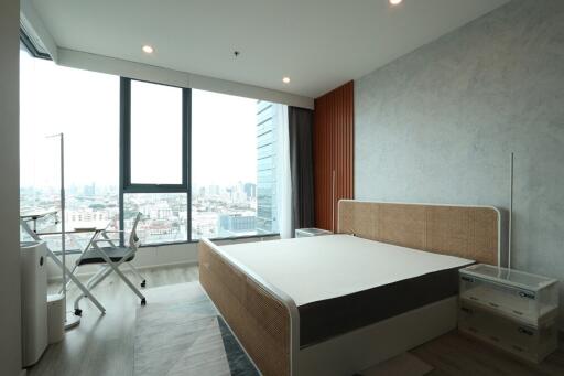Modern bedroom with large window overlooking cityscape