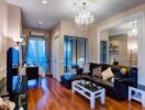 Modern living room with wooden flooring, chandelier, and glass windows