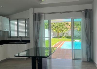 Modern living area with kitchen and view of a pool