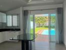 Modern living area with kitchen and view of a pool