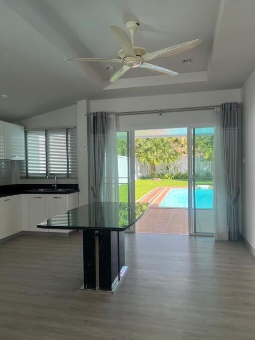 Modern living area with kitchen and view of a pool