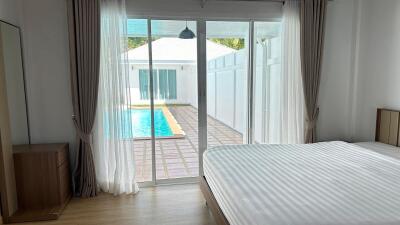 Bedroom with large sliding glass doors leading to a pool area