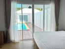 Bedroom with large sliding glass doors leading to a pool area