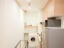 Compact laundry room with washing machine, refrigerator, and storage shelves
