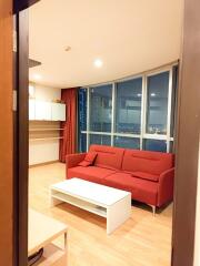 Living room with a red sofa and large windows