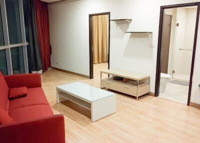 Living room with red couch and wooden flooring