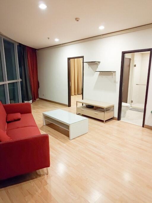 Living room with red couch and wooden flooring