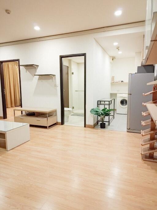 Main living space with light wood flooring, a bathroom, and laundry area