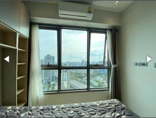 Bedroom with large window and city view