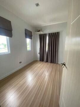 Bright empty bedroom with large windows and wooden floor