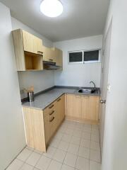 Compact kitchen with wooden cabinets and grey countertops