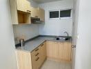 Compact kitchen with wooden cabinets and grey countertops