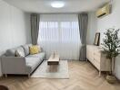 Modern living room with a grey sofa and herringbone flooring