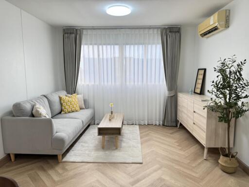 Modern living room with a grey sofa and herringbone flooring