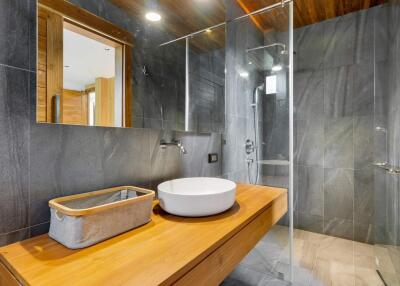 Modern bathroom with wooden countertop and glass shower
