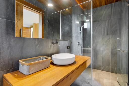 Modern bathroom with wooden countertop and glass shower