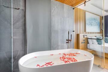 Modern bathroom with freestanding bathtub and flower petals in water