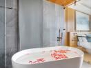 Modern bathroom with freestanding bathtub and flower petals in water